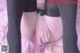 A close up of a person wearing black stockings and a pink skirt.