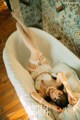 A woman laying in a bathtub with her legs up.