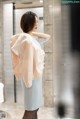 A woman standing in front of a mirror in a bathroom.