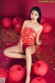 A woman in a red lingerie sitting on a red background surrounded by red lanterns.