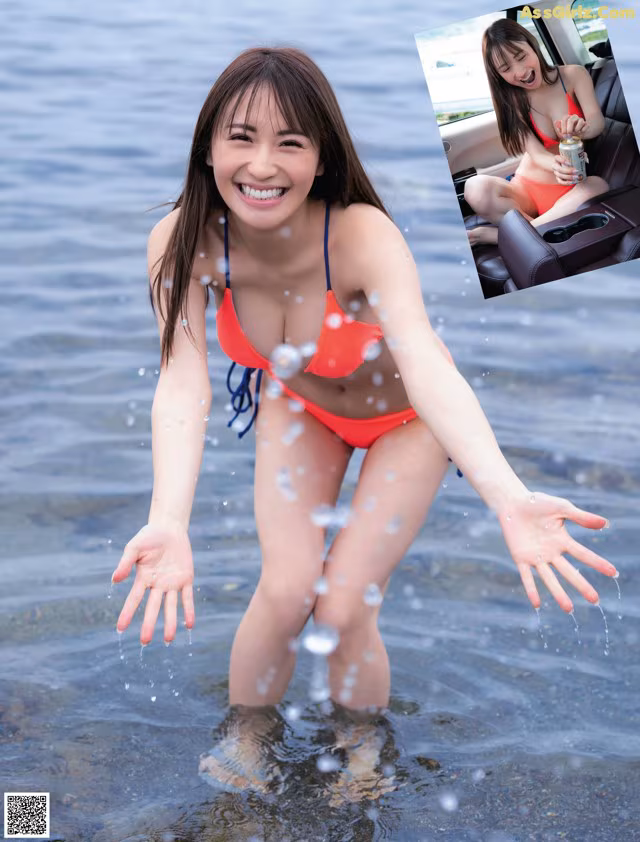 A woman in a red bikini standing in the water.