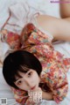 A woman laying on top of a bed in a kimono.