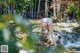 A woman in a bikini standing in a stream.