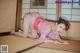 A woman in a pink kimono laying on the floor.