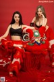 Two women dressed in red are posing for a picture.