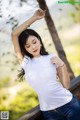 A woman in a white shirt and blue jeans posing for a picture.