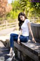 A woman sitting on a wooden bench in a park.