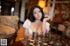 A woman sitting at a table playing chess.