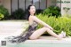 A woman sitting on the edge of a swimming pool.