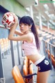 A woman holding a soccer ball in a stadium.