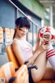 A woman sitting on a chair holding a soccer ball.