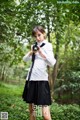 A woman in a school uniform holding a gun.