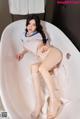 A woman sitting in a bathtub with her legs crossed.