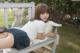 A woman laying on a bench with a stuffed animal.