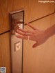 A woman's hand is pressing a button on a door.