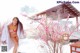 A woman in a pink bikini standing in the snow.