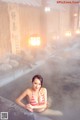 A woman in a bikini sitting in a hot tub.