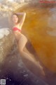 A woman in a red bikini sitting in a hot tub.