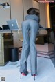 A woman standing in front of a desk with a laptop.