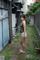 A woman standing in front of a blue building.